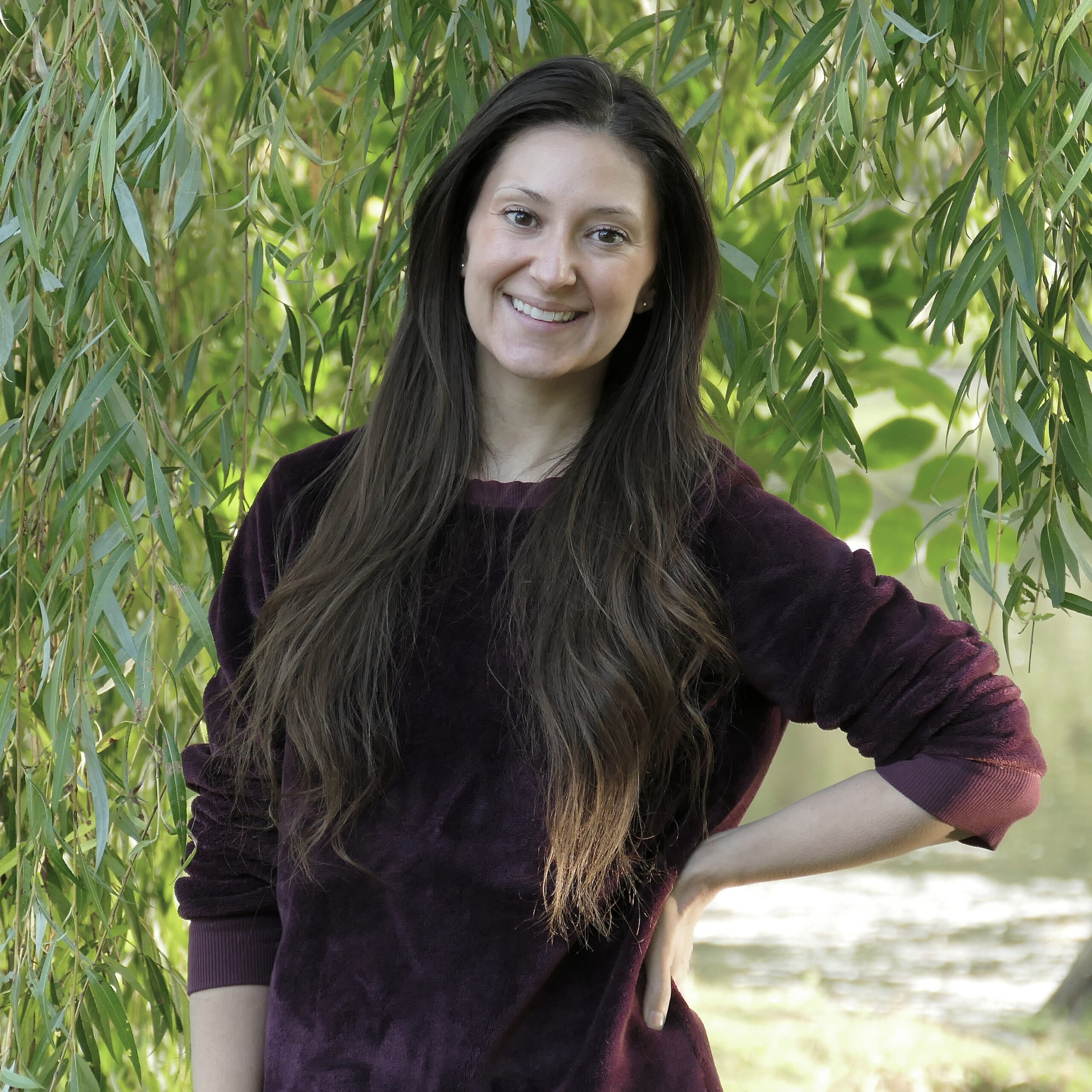 Photo de Jenny-Jane. Elle est en posture debout, dans un parc, devant un saule.